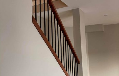 wooden rail staircase with white ceilings and grey walls in an esquimalt home in victoria