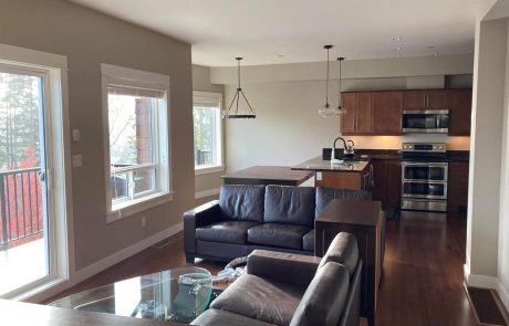 living room with leather furnitre and open concept kitchen in esquimalt home in victoria