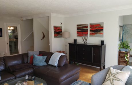 living room with dark furniture and red accent paintings