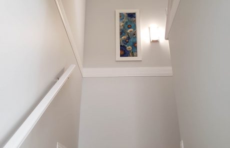 staircase leading upwards and a flower artwork hanging on the wall