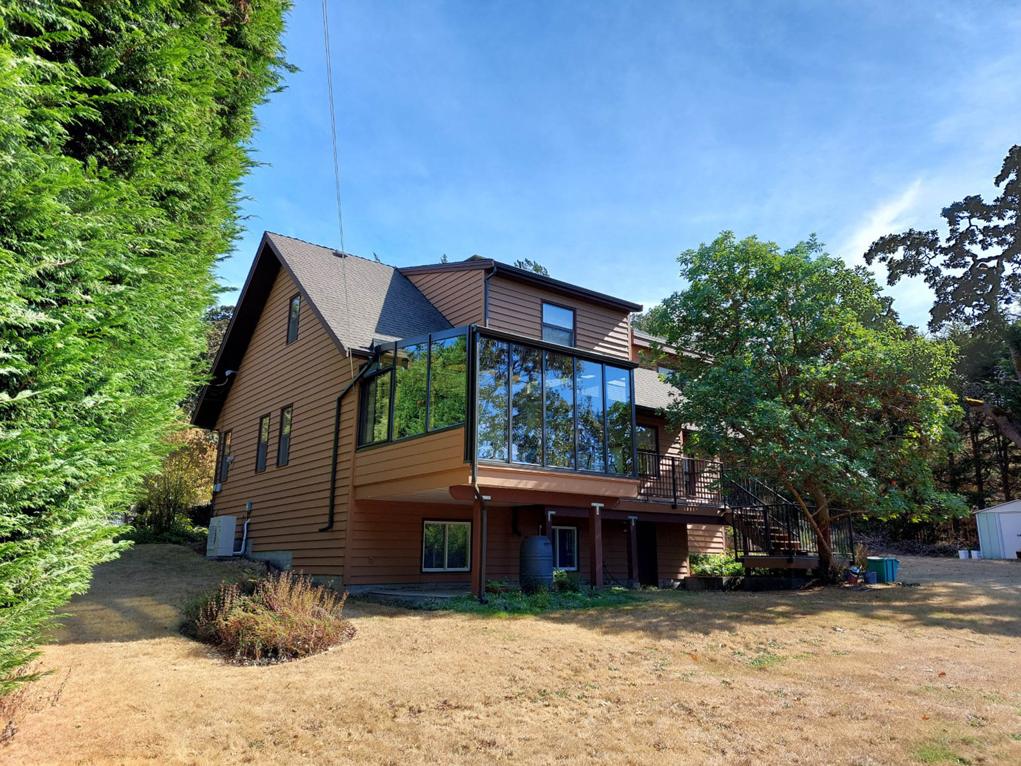 Back of a brown house with solarium and deck