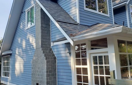 Exterior of a blue house and chimney in Metchosin