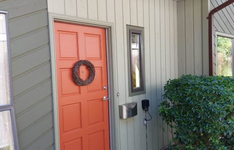 Orange painted front door of a olive green home in Oak Bay Victoria