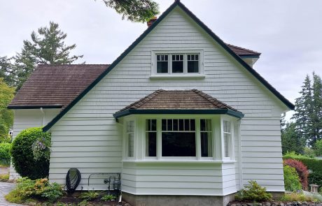 White house with bay windows and a lawn