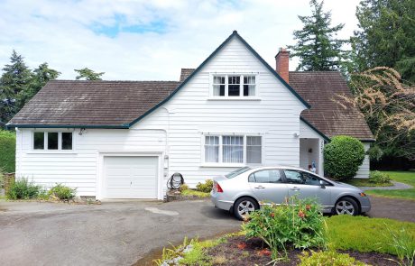 White house with a sedan car in the driveway located in arbutus cove