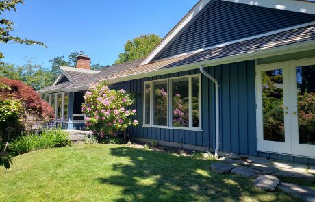 blue painted house with a rose bush in uplands victoria bc