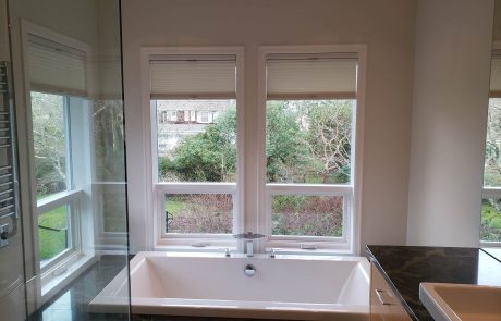 contemporary bathroom with large soaker tub and windows facing a garden in an uplands house in victoria