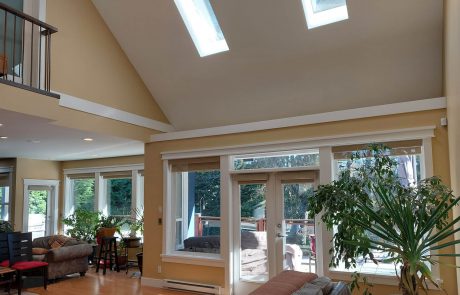 living room with vaulted ceilings and skylights, beige walls and hardwood flooring in a view royal house