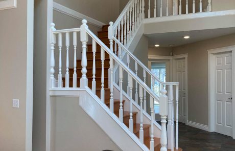 white wood railing staircase and grey walls inside a seapearl place home in victoria