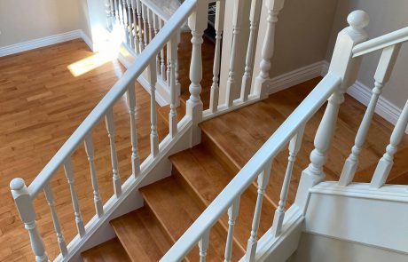overlooking a white railing staircase with hardwood floors