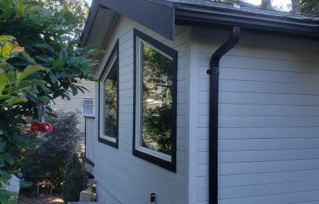 Side of a white house with black window frames in Panabode Victoria