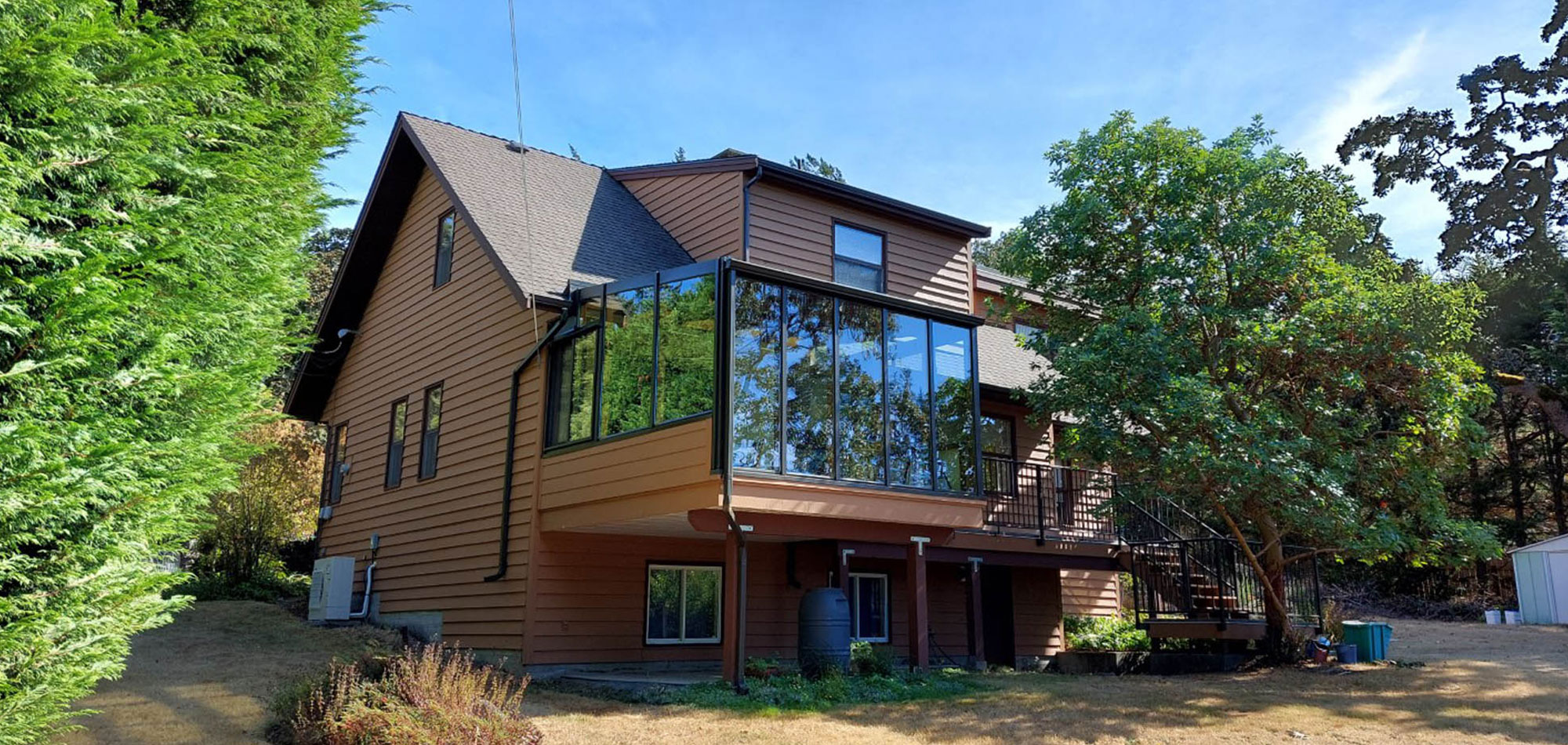 metchosin house with solarium surrounded by trees